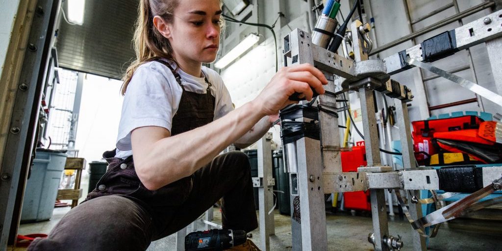 MIT-WHOI Joint Program Student Samantha Clevenger  attaches bathymetric and temperature sensors to several small surface-tethered traps that will collect organic carbon floating down in the ocean twilight zone. Photo by Danny Hentz, © WHOI