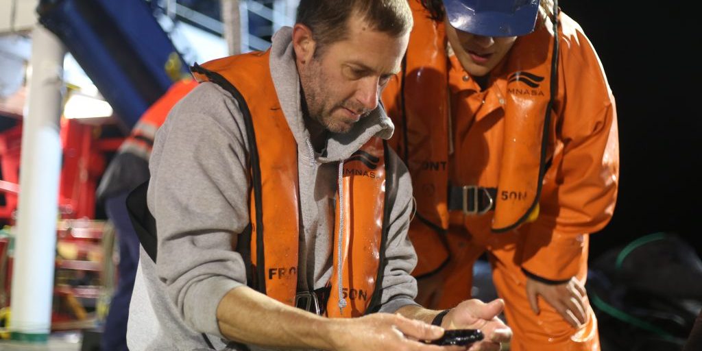 OTZ researcher Joel Llopiz (Left) examines a fish from the twilight zone during a net tow in 2021.